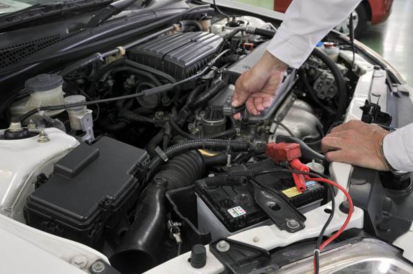 mechanic working on the engine of a car