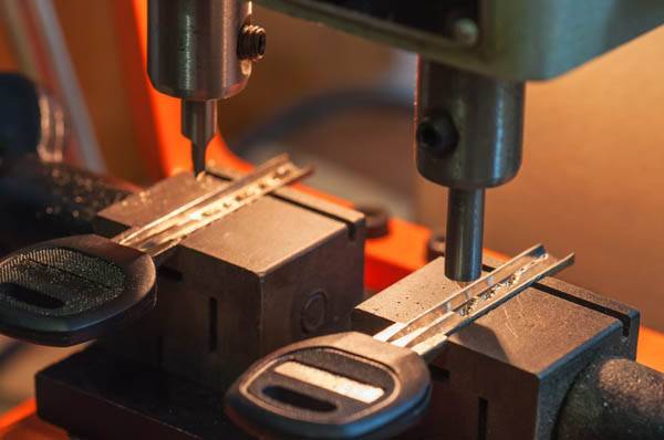 two car keys being cut by a mill